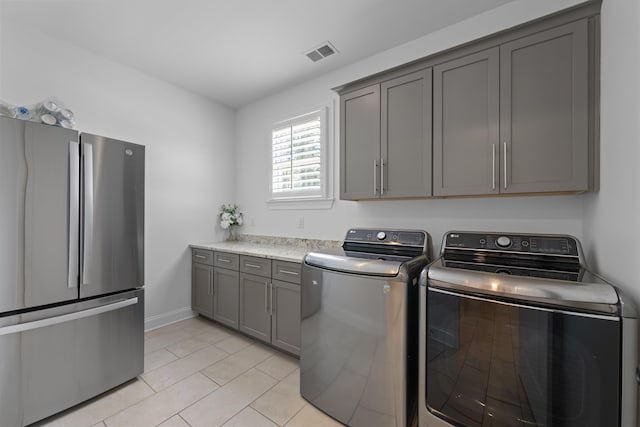 laundry room with washer and dryer, light tile patterned flooring, cabinet space, baseboards, and visible vents