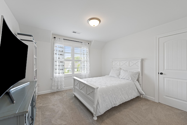 bedroom with visible vents, baseboards, and light carpet