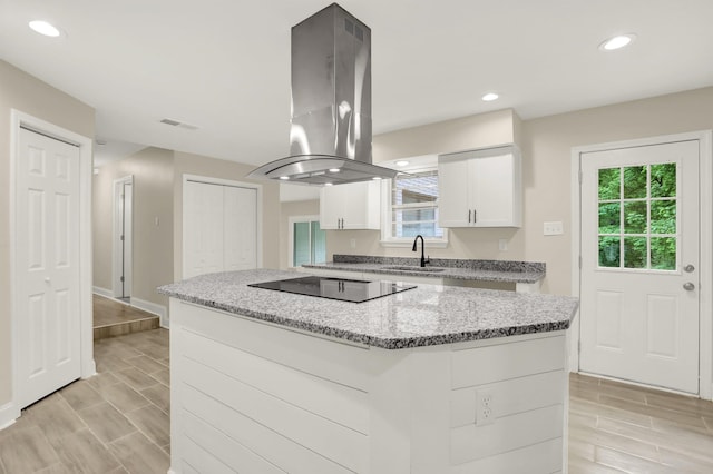 1296 Monasco Rd, Millington, TN 38053 - kitchen with a sink, black electric cooktop, a center island, white cabinetry, and island range hood