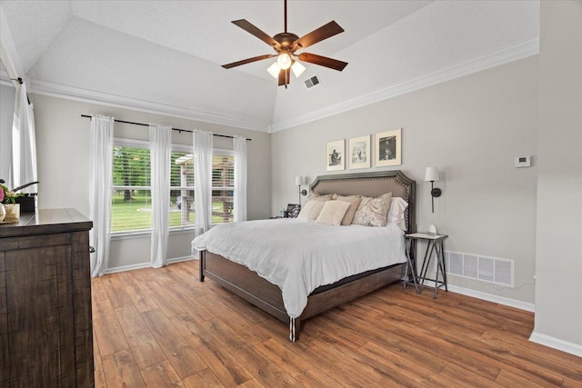 bedroom with vaulted ceiling, wood finished floors, and visible vents