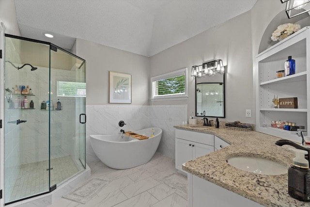 bathroom with double vanity, a sink, a freestanding tub, and a shower stall
