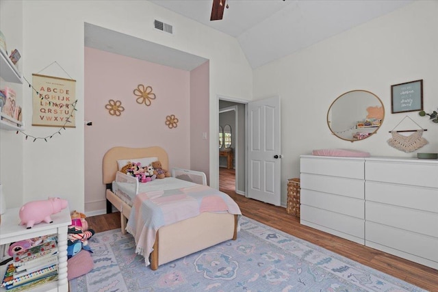 bedroom with a ceiling fan, visible vents, wood finished floors, and lofted ceiling