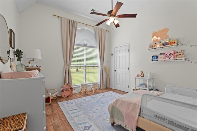 bedroom featuring a ceiling fan, vaulted ceiling, light wood-style flooring, and visible vents