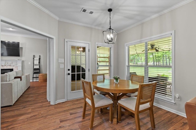 dining space featuring an inviting chandelier, ornamental molding, visible vents, and dark wood-type flooring