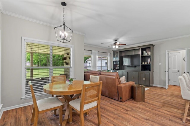 dining area featuring baseboards, ornamental molding, light wood finished floors, and ceiling fan with notable chandelier