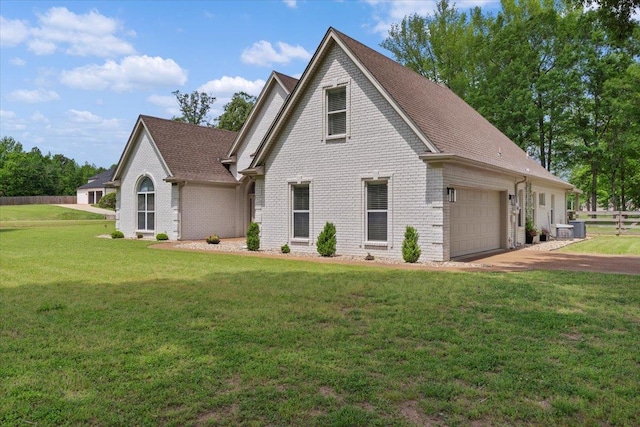 craftsman house featuring fence, a front lawn, brick siding, a garage, and driveway