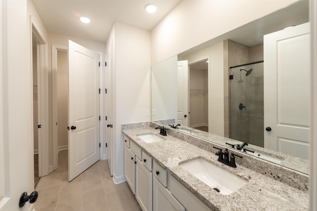 bathroom featuring a sink, a stall shower, and tile patterned floors