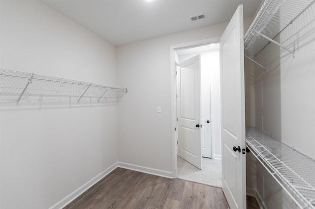 spacious closet featuring visible vents and wood finished floors