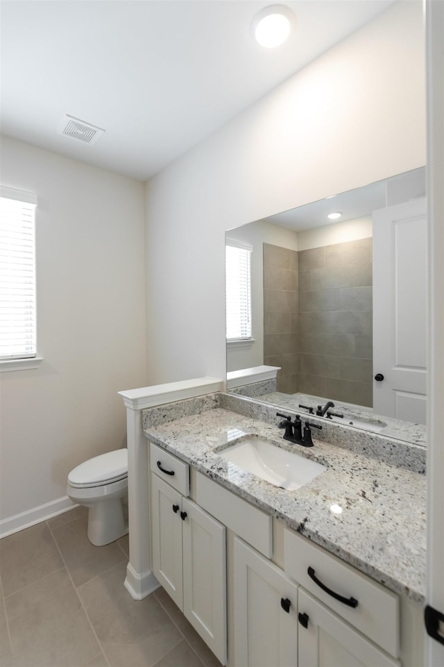 bathroom featuring visible vents, vanity, baseboards, tile patterned floors, and toilet