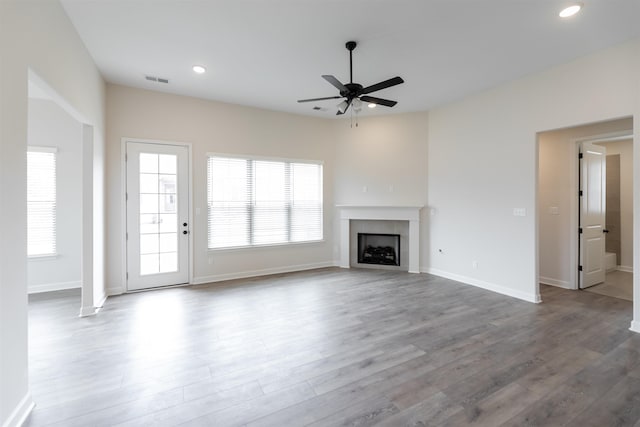 unfurnished living room featuring a ceiling fan, visible vents, a tiled fireplace, wood finished floors, and recessed lighting