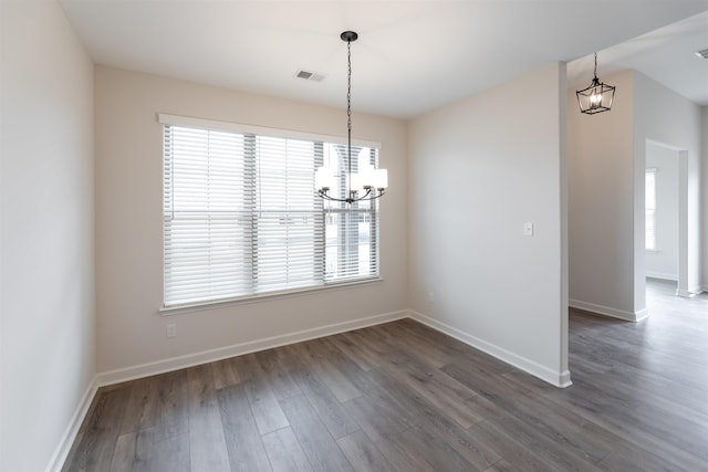unfurnished dining area with an inviting chandelier, baseboards, dark wood-style floors, and visible vents