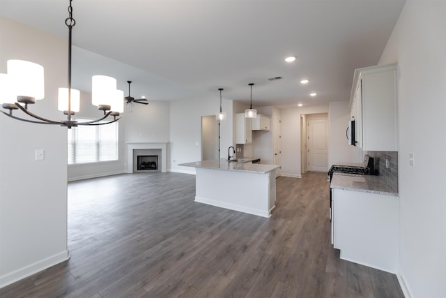 kitchen featuring recessed lighting, open floor plan, baseboards, and white cabinets