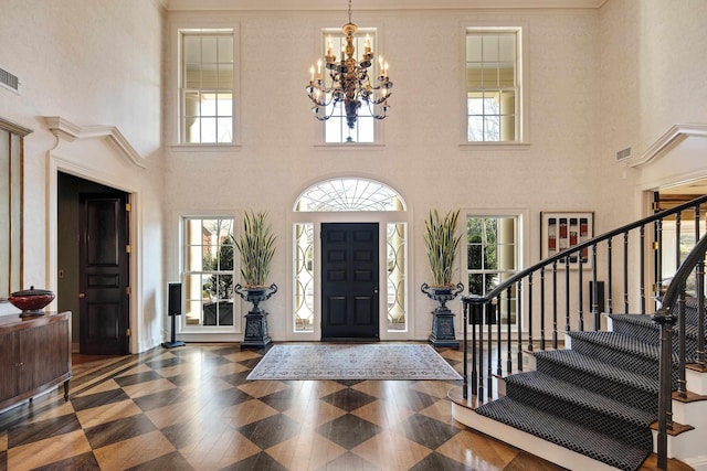 1055 Tides Ridge Cv, Memphis, TN 38120 - entrance foyer with an inviting chandelier, a high ceiling, stairway, and visible vents