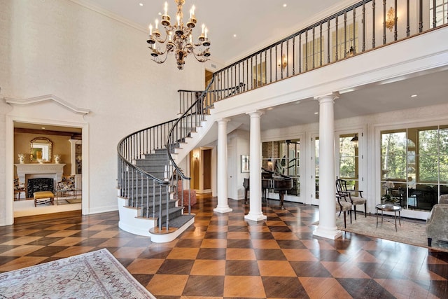 1055 Tides Ridge Cv, Memphis, TN 38120 - entrance foyer with ornate columns, a towering ceiling, stairway, and a fireplace