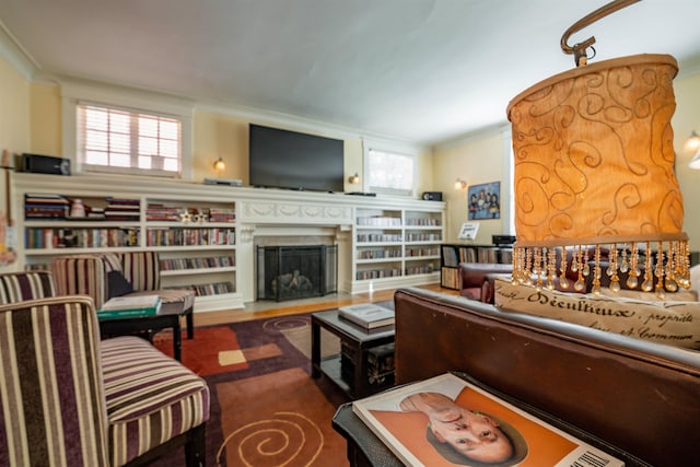 living room with crown molding, a fireplace, and wood finished floors