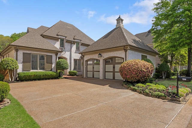 7298 Mont Blanc Dr, Germantown, TN 38138 - french provincial home featuring brick siding, a garage, roof with shingles, and driveway