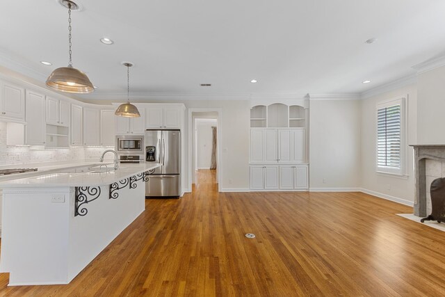 7298 Mont Blanc Dr, Germantown, TN 38138 - kitchen with white cabinets, open shelves, appliances with stainless steel finishes, light countertops, and ornamental molding