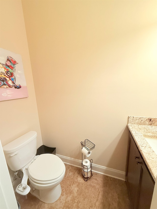 bathroom with toilet, baseboards, tile patterned floors, and vanity