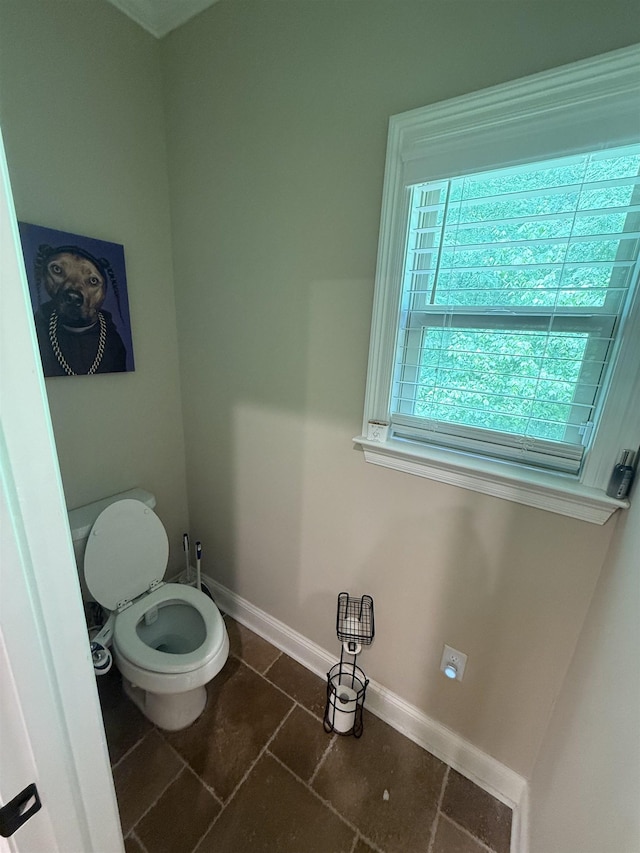 bathroom with baseboards, tile patterned flooring, and toilet