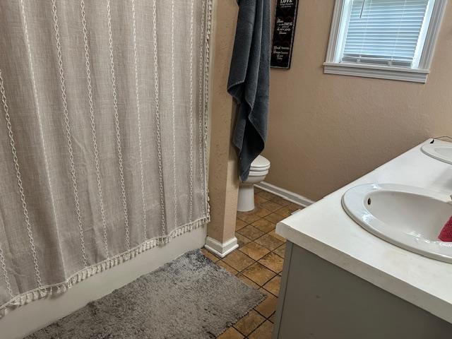85 Two Boys Rd, Savannah, TN 38372 - full bath with double vanity, tile patterned flooring, toilet, shower / bathtub combination with curtain, and baseboards