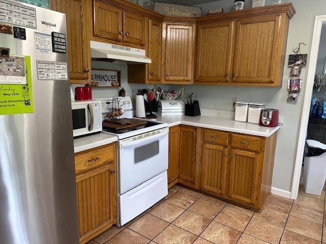 85 Two Boys Rd, Savannah, TN 38372 - kitchen featuring white appliances, under cabinet range hood, brown cabinetry, and light countertops