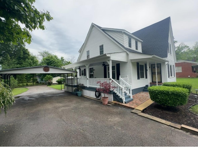 bungalow featuring covered porch, ceiling fan, a detached carport, and aphalt driveway