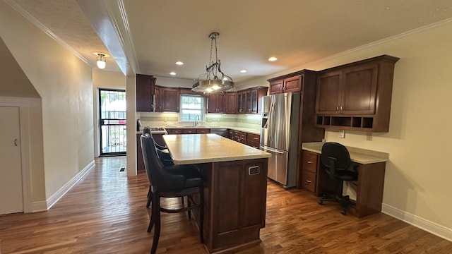 kitchen with a kitchen island, light countertops, stainless steel fridge with ice dispenser, baseboards, and ornamental molding