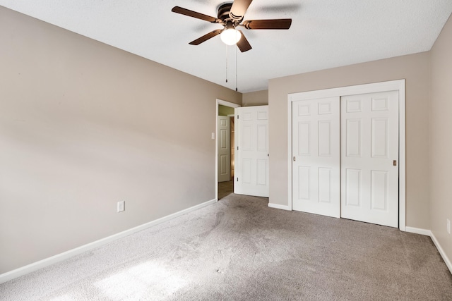 unfurnished bedroom with carpet flooring, baseboards, ceiling fan, and a closet