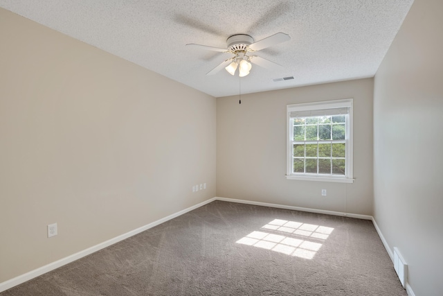 empty room featuring visible vents, carpet, and ceiling fan