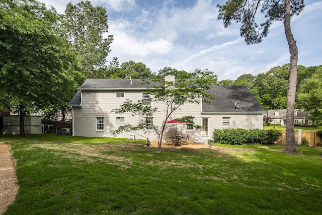rear view of property with central AC, fence, a yard, and a chimney