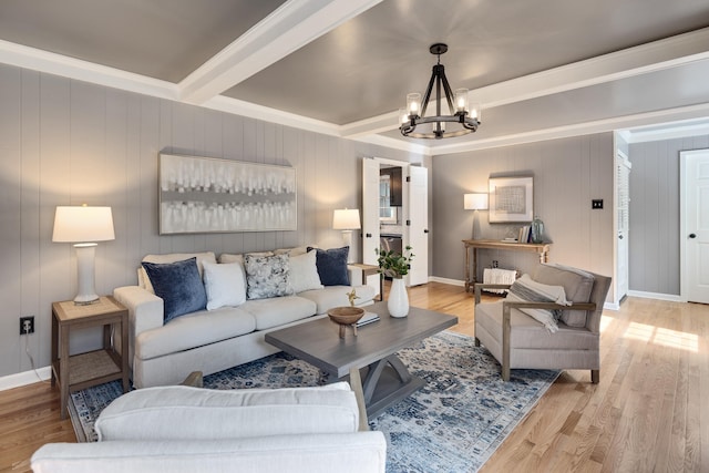 living area with crown molding, light wood finished floors, a chandelier, baseboards, and beamed ceiling