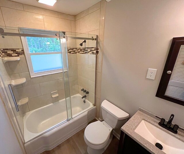 4485 Dunn Rd, Memphis, TN 38117 - bathroom with toilet, wood finished floors, shower / bath combination with glass door, and vanity