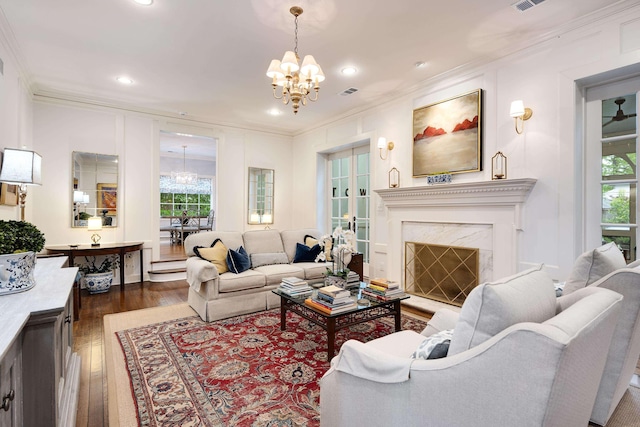 living area with plenty of natural light, ornamental molding, a chandelier, and dark wood-style floors