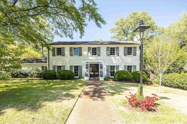colonial home with french doors and a front lawn
