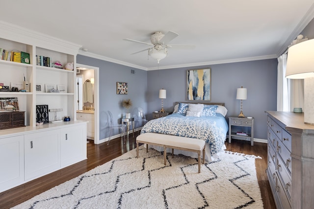 bedroom with crown molding, baseboards, dark wood-type flooring, a ceiling fan, and ensuite bath