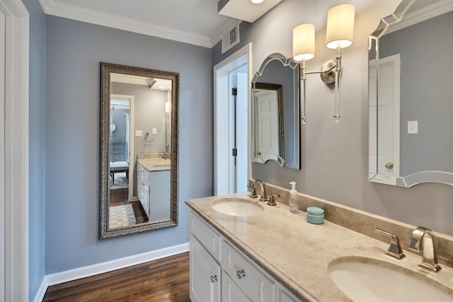 bathroom with double vanity, a sink, wood finished floors, and ornamental molding
