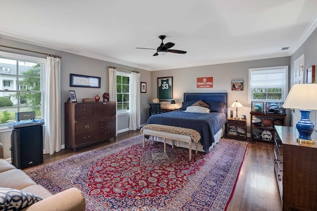 bedroom with visible vents, crown molding, wood finished floors, and ceiling fan
