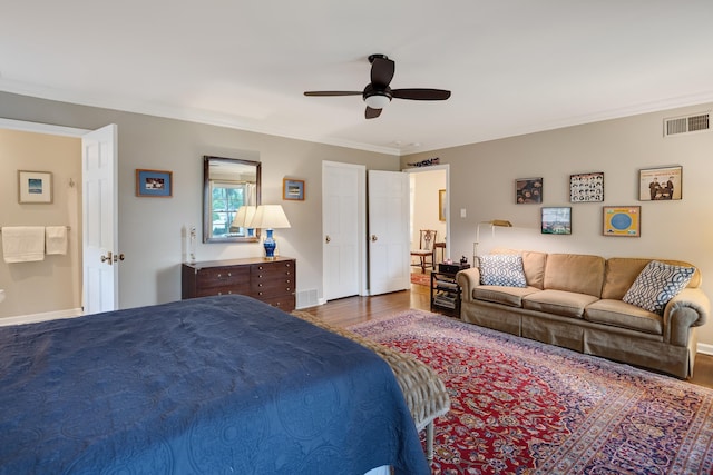 bedroom featuring crown molding, baseboards, wood finished floors, and visible vents