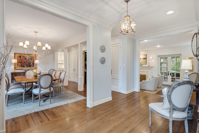 dining area with baseboards, a chandelier, ornamental molding, and wood finished floors