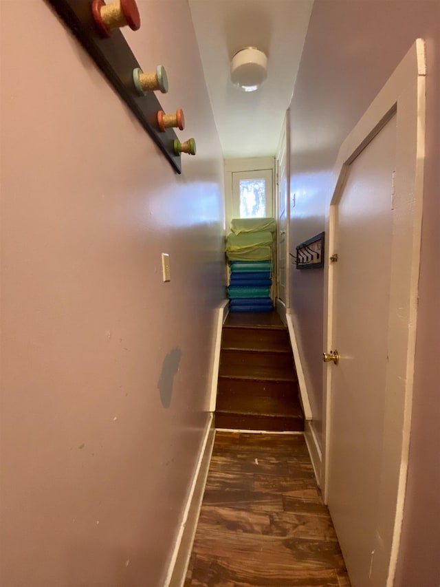 staircase featuring baseboards and wood finished floors