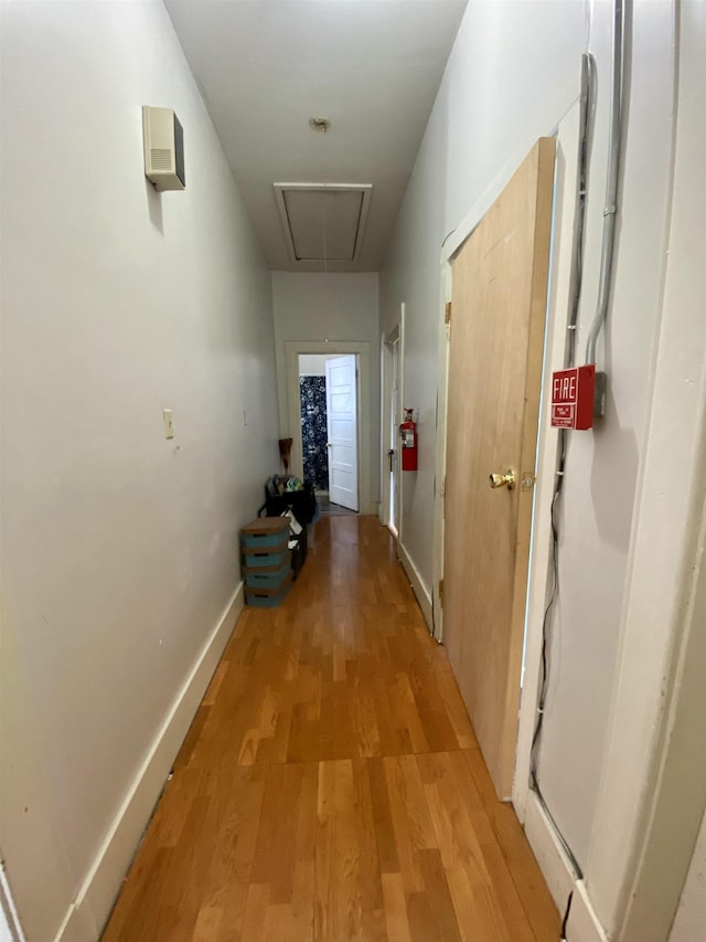 hall featuring light wood-style floors and attic access