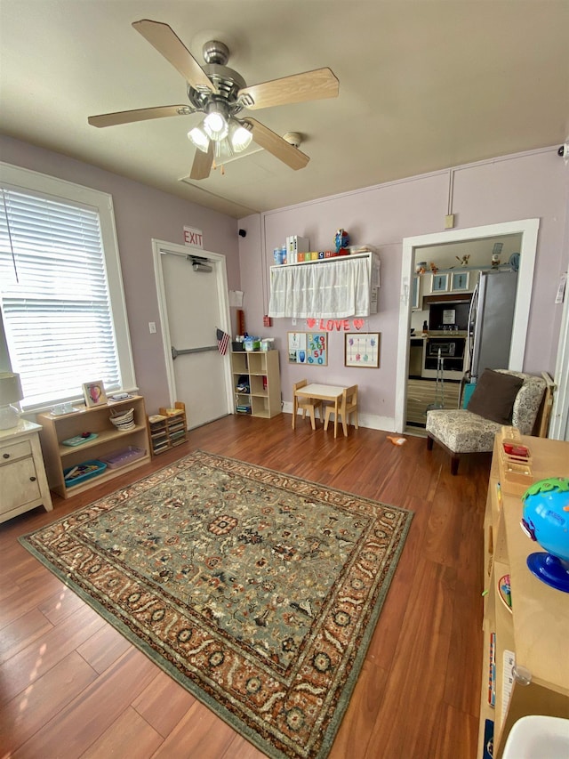 living area with ceiling fan and wood finished floors