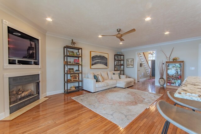164B Aquaticview Way, Savannah, TN 38372 - living area featuring stairs, crown molding, a fireplace with flush hearth, and wood-type flooring