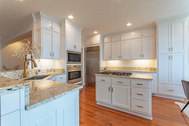 164B Aquaticview Way, Savannah, TN 38372 - kitchen with a sink, white cabinets, a peninsula, light wood-style floors, and built in appliances