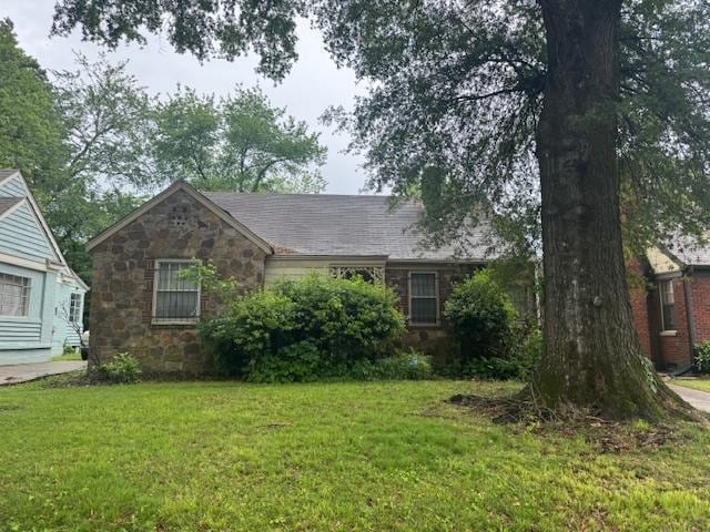 view of front of home with a front lawn and stone siding