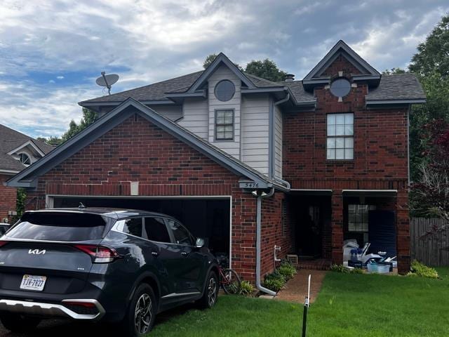 view of front of home with a garage, a front lawn, roof with shingles, brick siding, and driveway