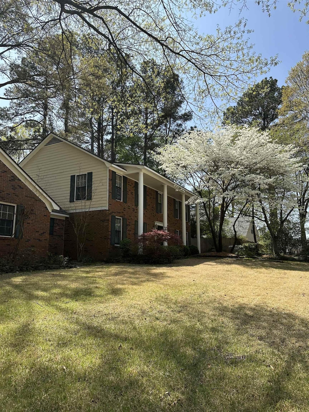 exterior space featuring a lawn and brick siding