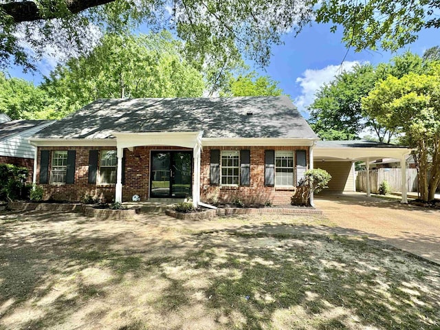 ranch-style house with fence, an attached carport, driveway, and brick siding