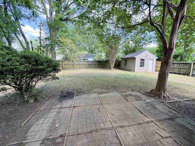 view of yard featuring a fenced backyard, an outbuilding, and a patio area