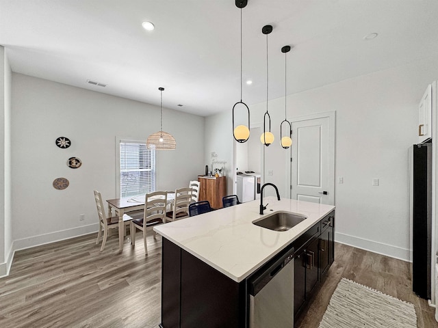 kitchen featuring a sink, dishwasher, freestanding refrigerator, wood finished floors, and visible vents